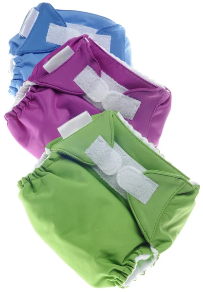 Экологичные тканевые подгузники в зеленом, фиолетовом и синем цветах — стоковое фото