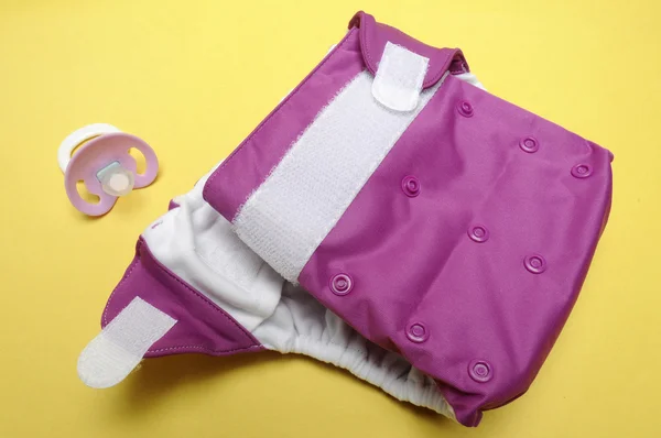 Open Eco Friendly Cloth Diaper with Dummy on Yellow Background Royaltyfria Stockbilder