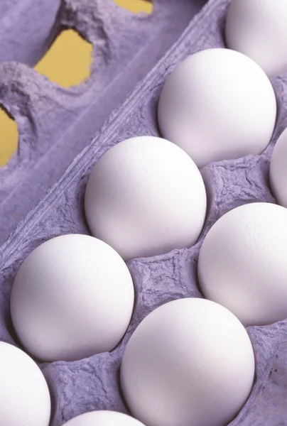 Des douzaines d'œufs sur fond jaune — Photo