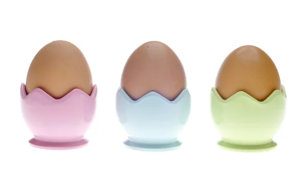 Tre tazze di uova pastello con uova marroni — Foto Stock