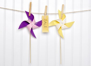 Summer Sale Concept Pinwheels with Sale Sign on Clothesline. clipart