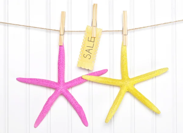 Морская тематическая продажа морской звезды со знаком на верёвке одежды — стоковое фото