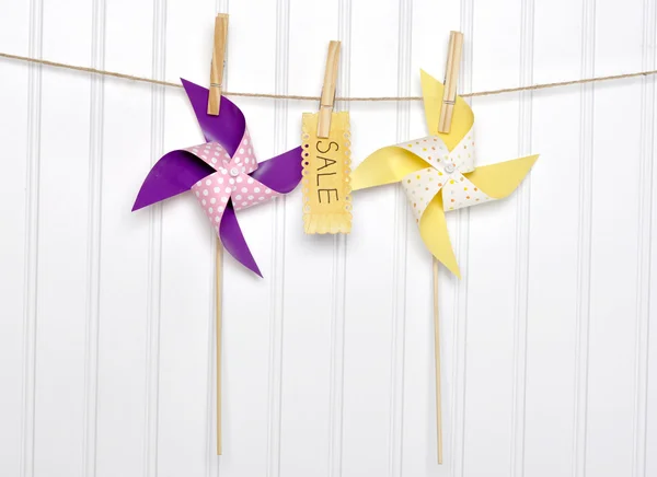Letní prodej koncept pinwheels s prodejem podepsat na prádelní šňůru. — Stock fotografie