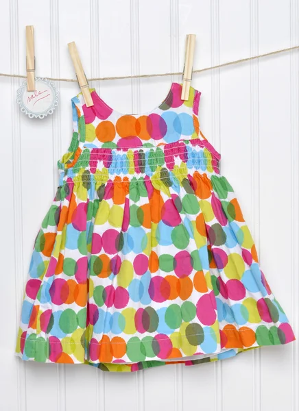 Детское платье Polka Dot на веревке для одежды с вывеской "Продажа от руки" — стоковое фото