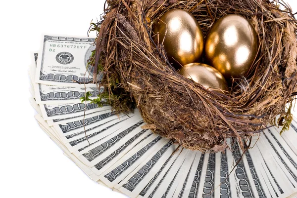 Tres huevos de oro en el nido. Un símbolo de hacer dinero y succ —  Fotos de Stock