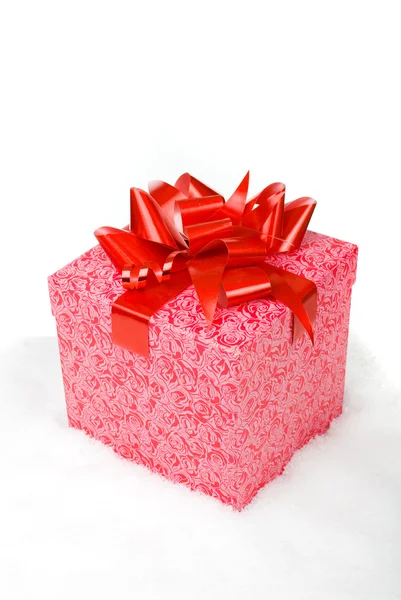 De doos van de rode gift van Kerstmis met lint in sneeuw op een witte achtergrond — Stockfoto