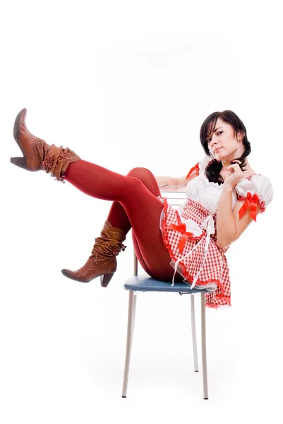 Beyaz zemin üzerinde bir sandalyede oturan Kırmızı elbiseli seksi kadın — Stok fotoğraf
