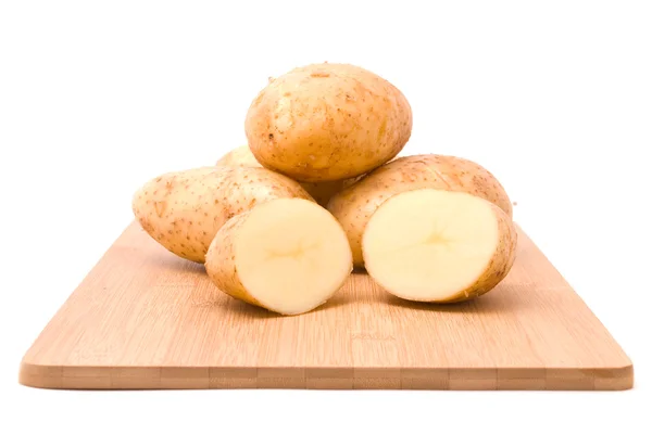 Свежий картофель с доской на белом фоне — стоковое фото