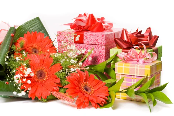 Magnificent bouquet gerbera and present boxes on a white — Stock Photo, Image