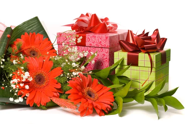 Prachtvoller Strauß Gerbera und Geschenkschachteln auf einem weißen — Stockfoto