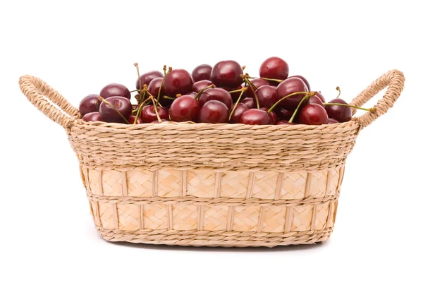Красные вишни в деревянной корзине изолированы на белом — стоковое фото
