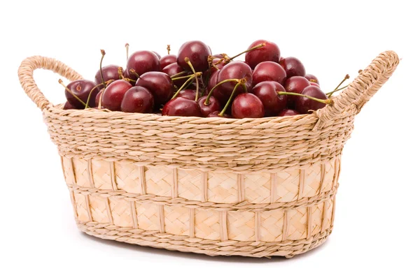 Röda körsbär i trä korg isolerad på vitt — Stockfoto