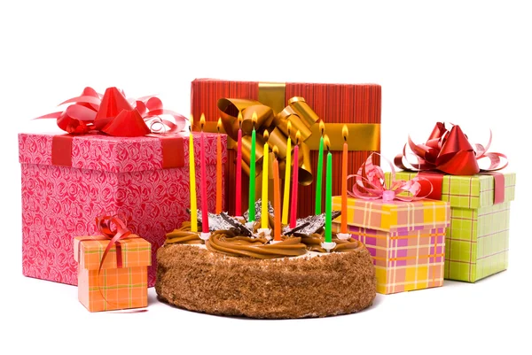 Kuchen mit zwölf Kerzen und Geschenken in Schachteln auf weißem Hintergrund — Stockfoto