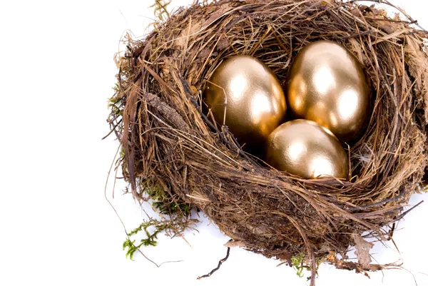 Tre uova d'oro nel nido isolate su fondo bianco — Foto Stock
