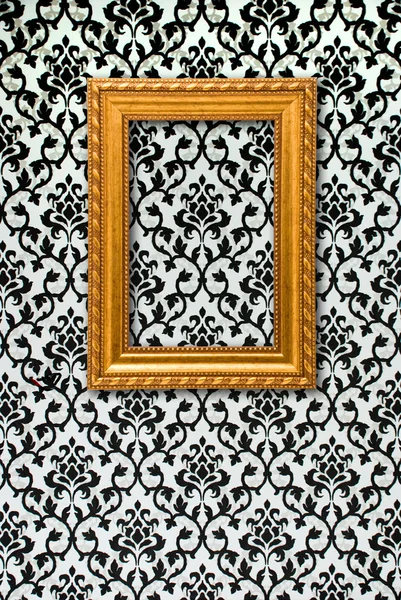 Gold frame on a black and white wallpaper — Stock Photo, Image