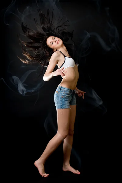 Beautiful sexy woman dancing in smoke on black background — Stock Photo, Image