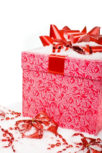 De doos van de rode gift van Kerstmis met lint in sneeuw op een witte achtergrond — Stockfoto