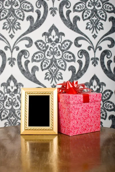 ゴールデン フォト フレームやテーブルの上にプレゼント ボックス — ストック写真