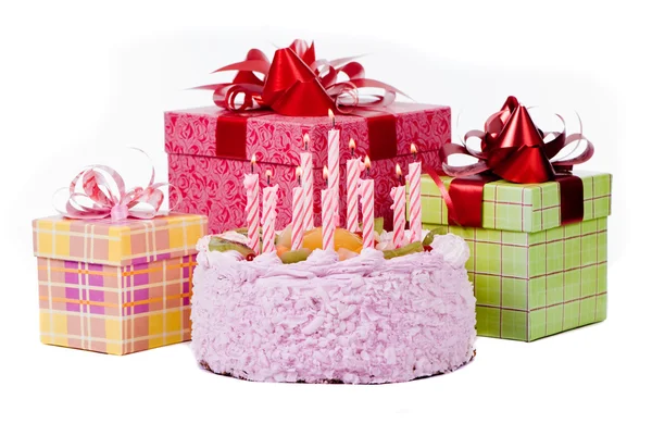 Torta con dieci candele e regali in scatole su sfondo bianco — Foto Stock