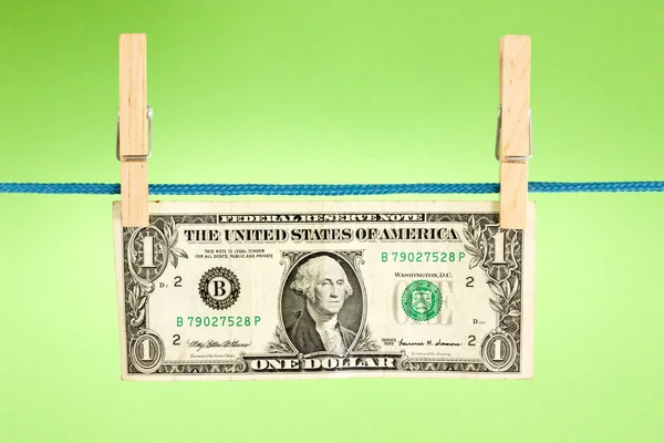 Dollaro appeso sopra uno sfondo verde — Foto Stock