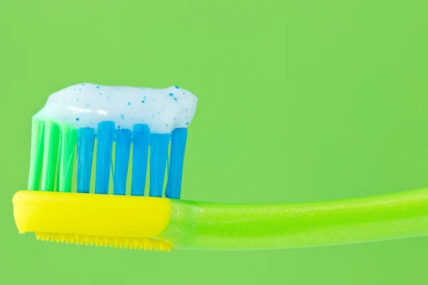 Zahnbürste auf grünem Hintergrund — Stockfoto