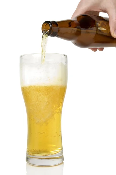 Beer pouring from bottle into glass — Stock Photo, Image