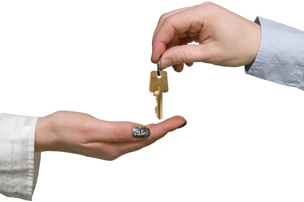 Hand giving a golden key to another hand — Stock Photo, Image