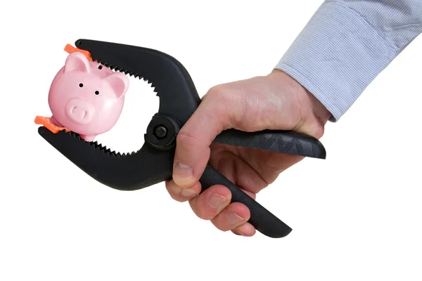 Businessman squeezing piggy bank in a clamp — Stock Photo, Image