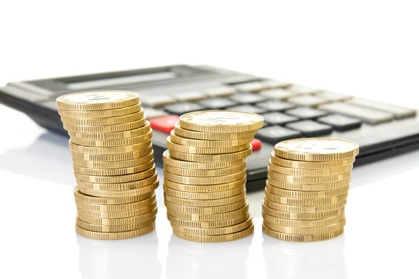 Calculator and three stacks of coins — Stock Photo, Image