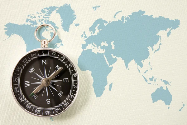 Schwarzer Kompass auf blau Weltkarte — Stockfoto