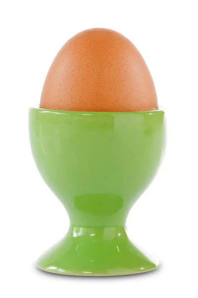 Braunes Ei in einer Tasse grün — Stockfoto