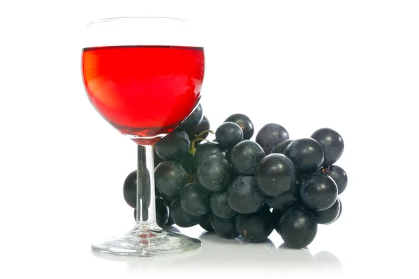 Červené víno ve skle s hroznovým vínem — Stock fotografie