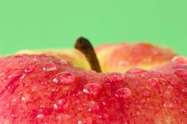 Wet apple on a green background — Stock Photo, Image