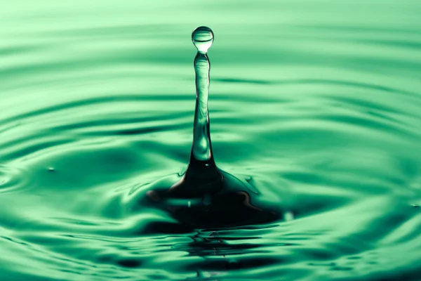 Drop falling into green water — Stock Photo, Image