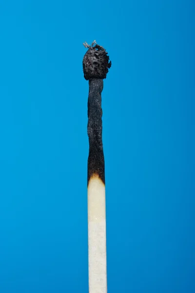 Burnt match stick isolated on blue — Stock Photo, Image