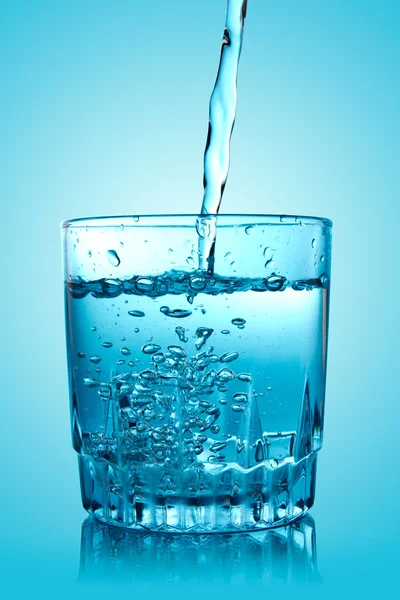Bicchiere di acqua versante con riflesso — Foto Stock