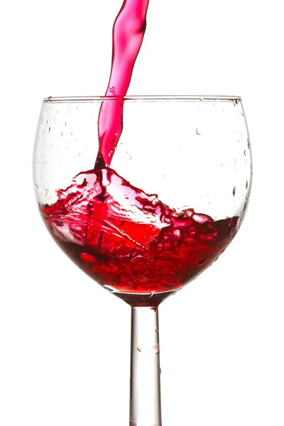 Красное вино, разливающееся в бокал — стоковое фото