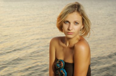 Portrait of a fashionable young women against sunset on a river