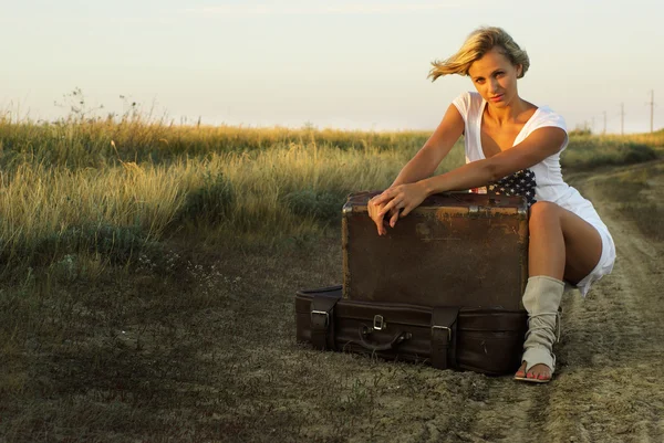 Chica bonita con una maleta en un camino rural —  Fotos de Stock