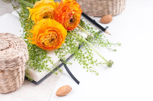 Yellow flowers, wicker baskets and a notebook — Stock Photo, Image