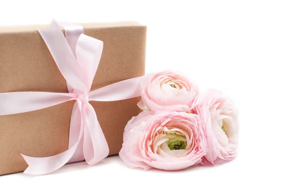 Δώρο δεμένο με κορδέλα και ροζ λουλούδια — Φωτογραφία Αρχείου