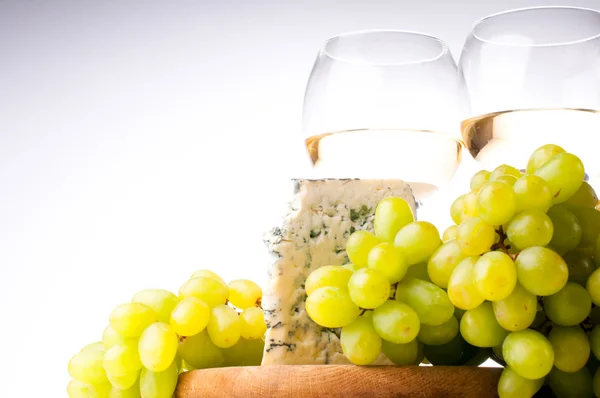 Twee glazen van witte wijn, blauwe kaas en een druiven — Stockfoto