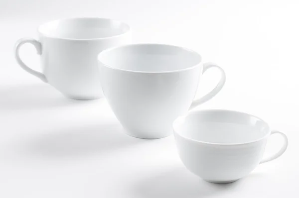 Три разных белых чашки — стоковое фото