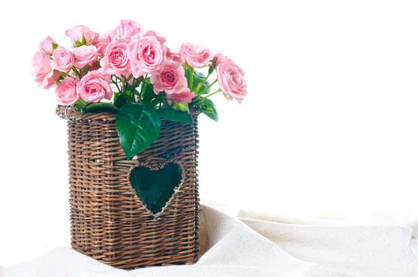 Mawar merah muda dalam keranjang wicker dan kain linen — Stok Foto