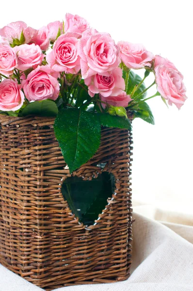 Розовые розы в плетеной корзине и льняной ткани — стоковое фото