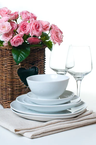 Dishes, towels and a basket of flowers — Stock Photo, Image