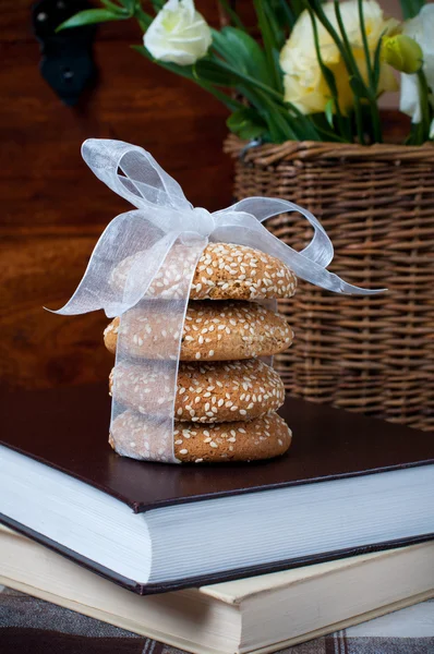 Cookies with a ribbon, books, and a bouquet — Stock Photo, Image