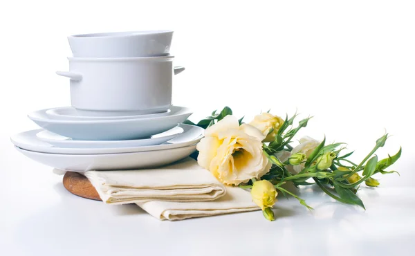 Plates and a bouquet of yellow flowers — Stock Photo, Image