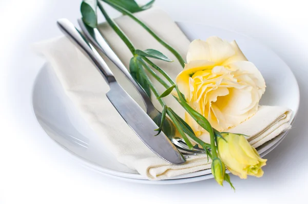Plaat, bestek en geel bloem — Stockfoto