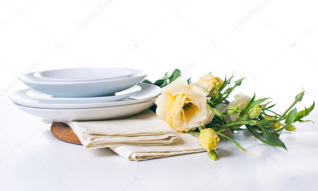 Plates and a bouquet of yellow flowers